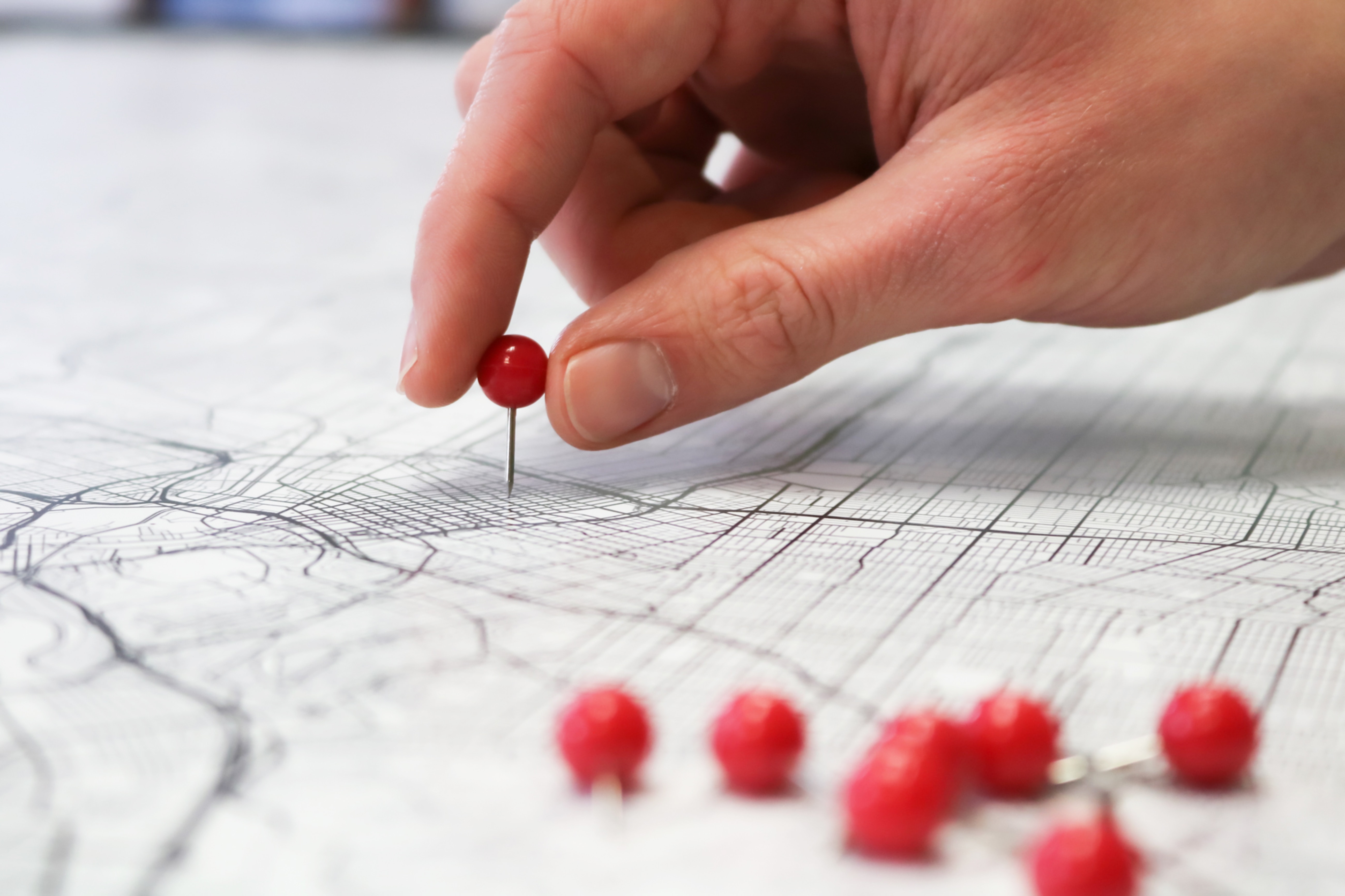 Red pins on a white map